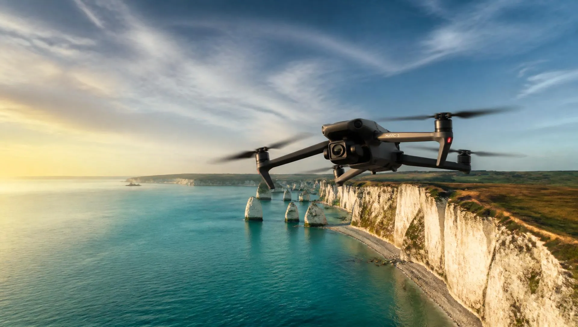 DJI Mavic in flight over white chalk cliffs and turquoise sea at golden hour